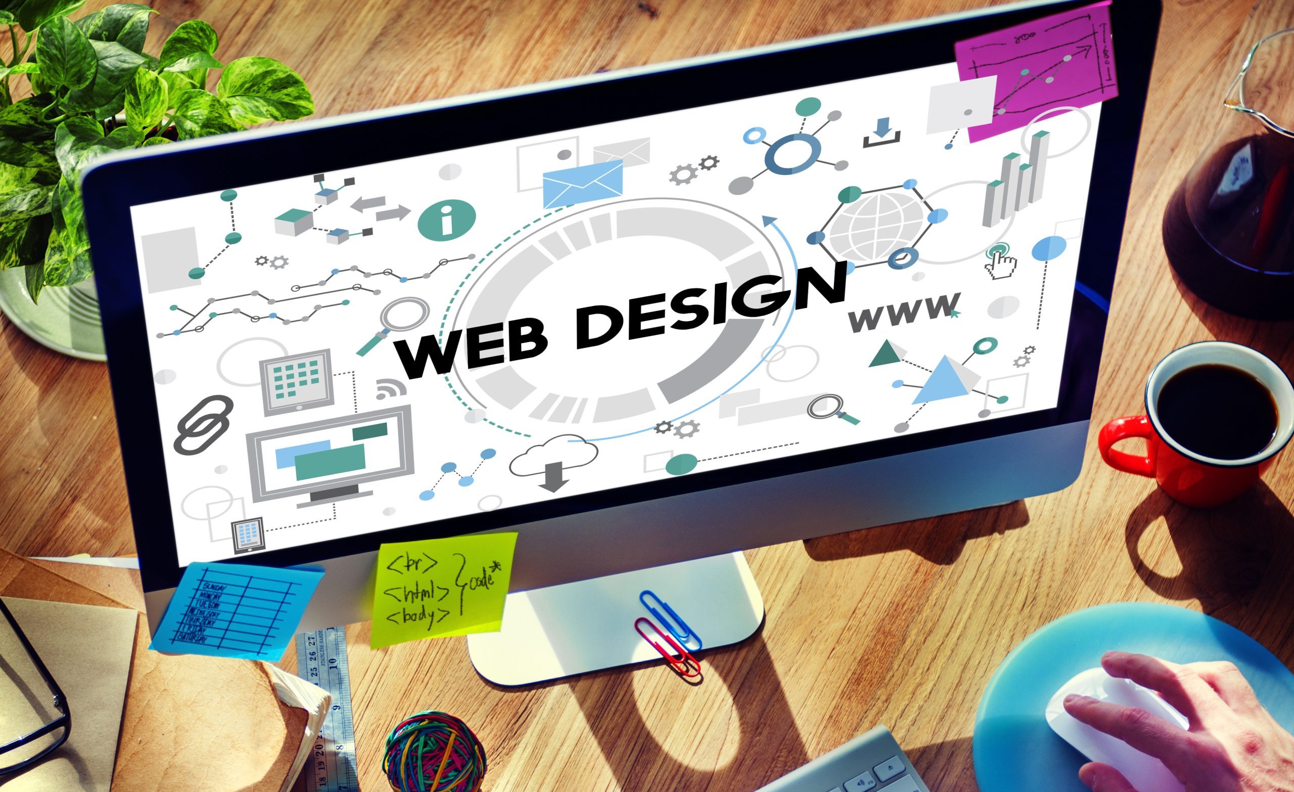 Desktop screen displaying a central "Web Design" diagram, with code snippets and sticky notes on the monitor base.